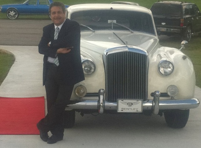 Chauffeur standing in front of luxury car